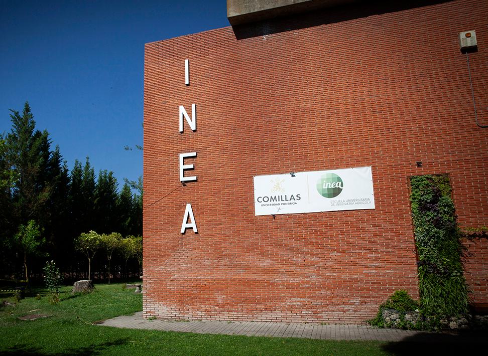 Edificio de ladrillo con el nombre INEA y un cartel que indica Comillas.