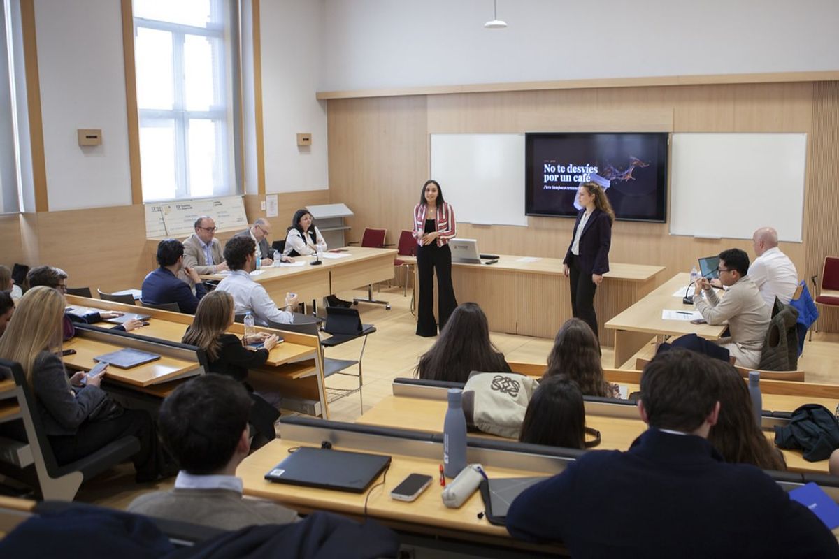 Un grupo de personas asiste a una presentación en un aula moderna.
