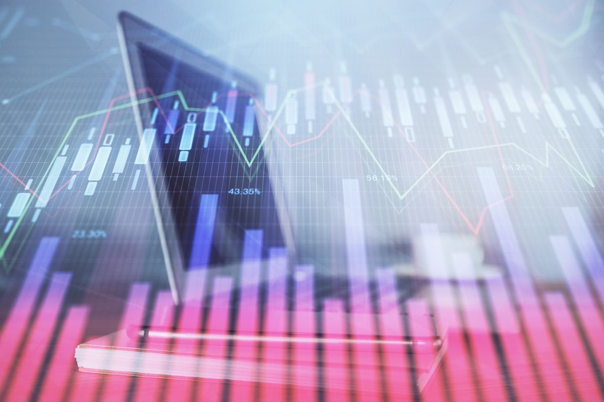 Graphical representation of financial stock market data with rising and falling lines on a blurred background.