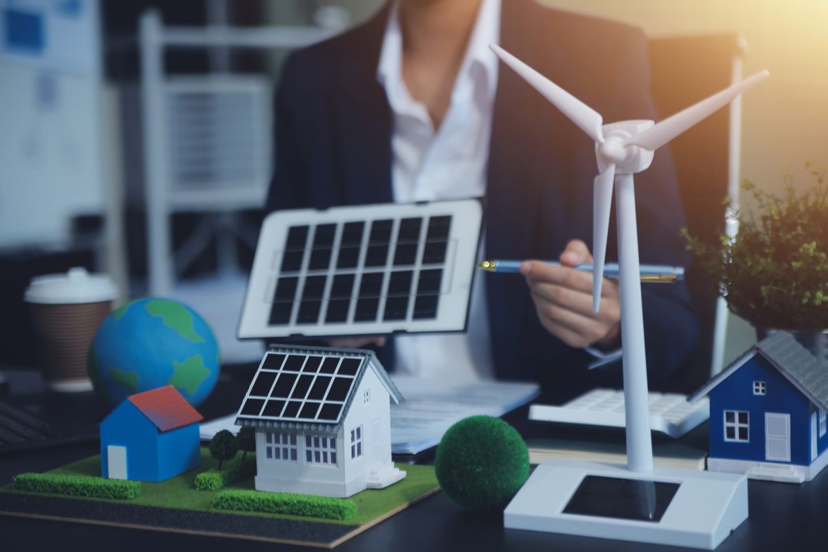 Una persona muestra modelos de energías renovables en una mesa de trabajo.