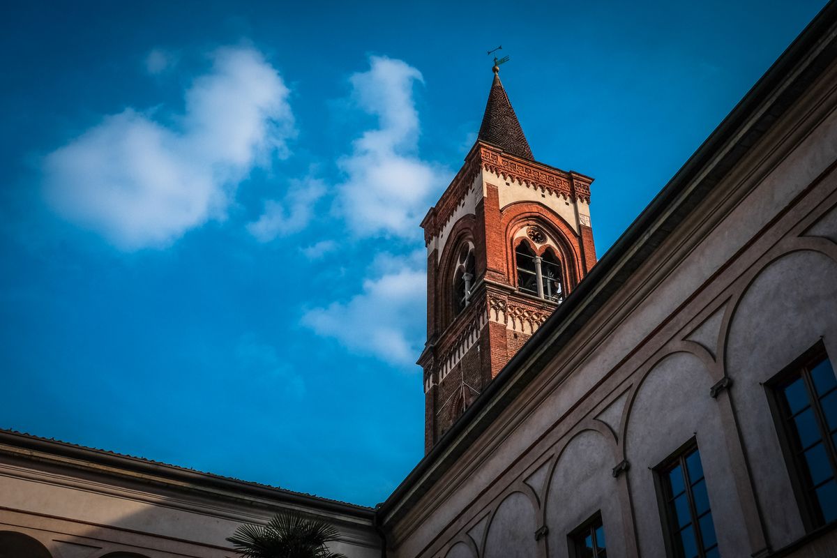 Una imagen de una torre de iglesia con un fondo de cielo azul y algunas nubes.