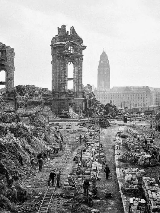 Una vista de un paisaje urbano en ruinas, con edificios destruidos y escombros en el suelo.