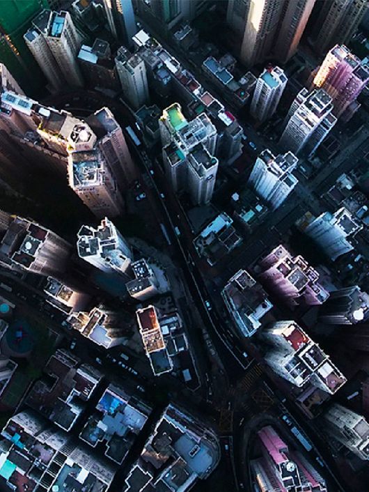 La imagen muestra una vista aérea de un denso paisaje urbano con rascacielos en distintas alturas y colores.