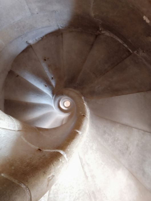 Una vista desde arriba de una escalera en espiral de piedra.