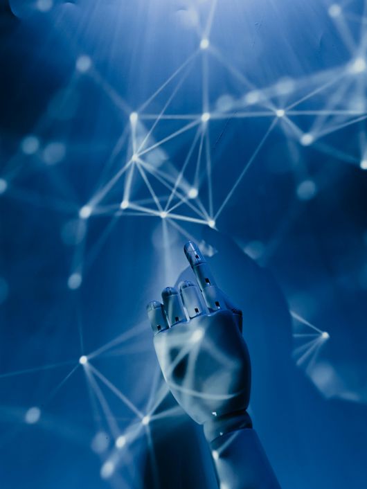 Una mano robótica señala hacia un fondo de conexiones digitales brillantes.