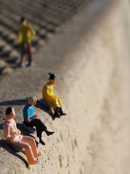 Varias figuras de plástico sentadas sobre una superficie de cemento.