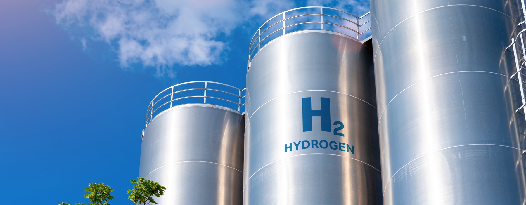 La imagen muestra tanques de almacenamiento de hidrógeno bajo un cielo despejado.