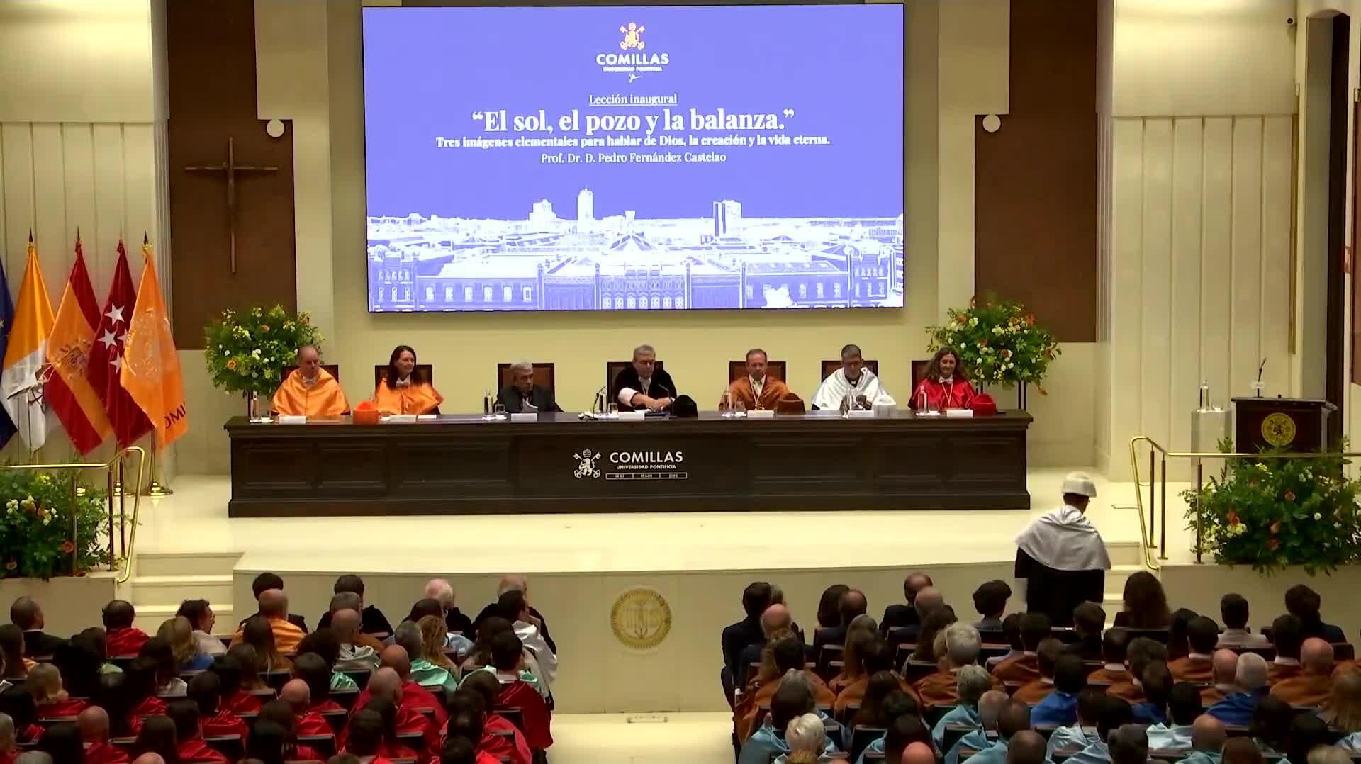 Un evento académico en una sala con un panel de oradores y una audiencia numerosa.