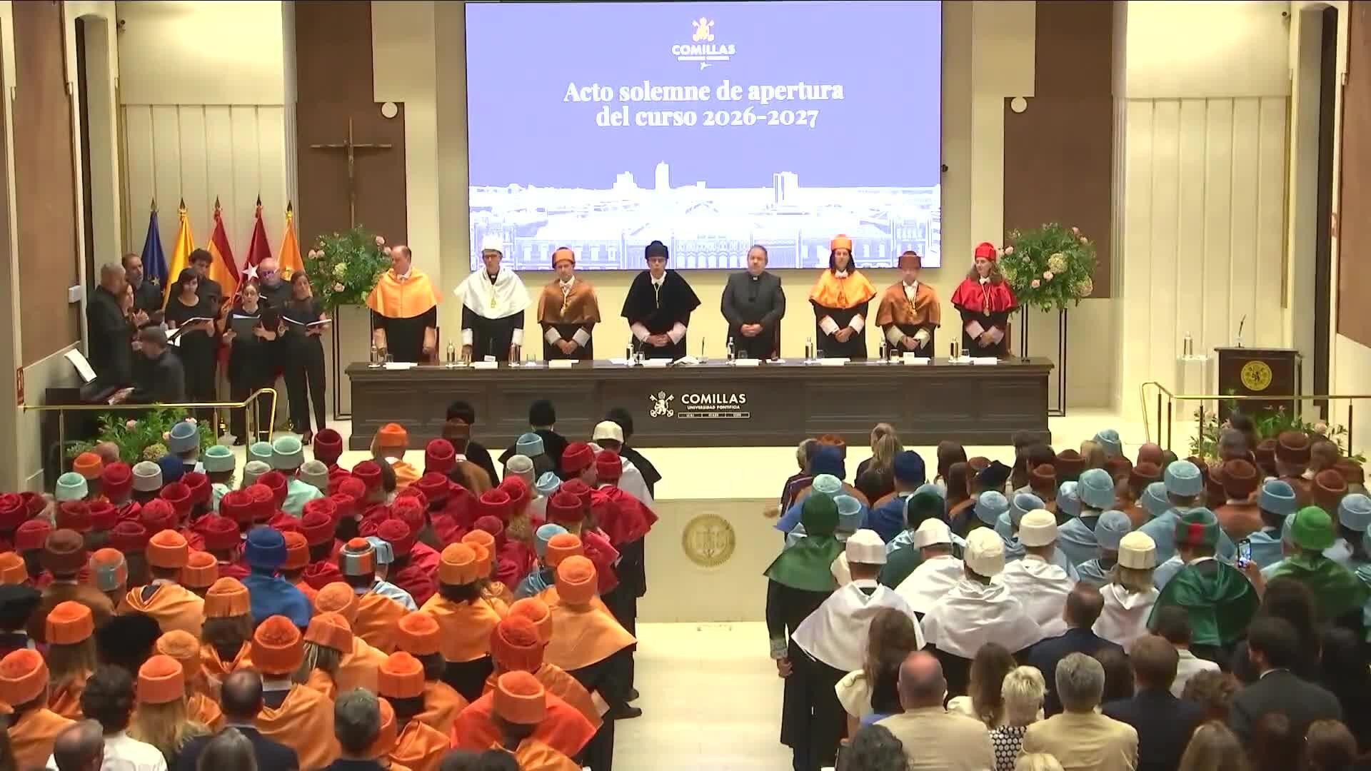 El acto solemne de apertura del curso 2026-2027 se celebra con estudiantes vestidos de diferentes colores en un auditorio.