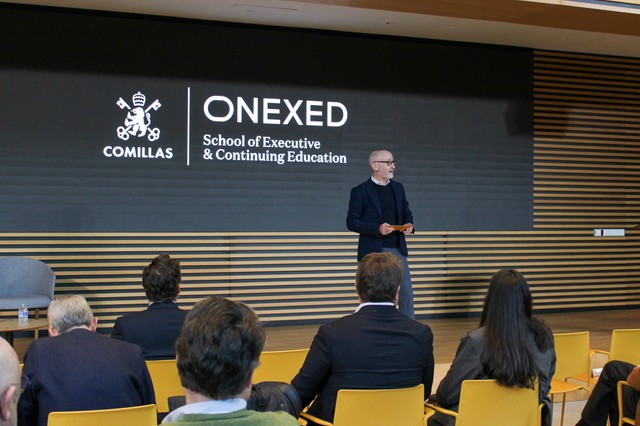 Un orador se presenta ante un público en un evento educativo organizado por ONEXED de la Universidad de Comillas.