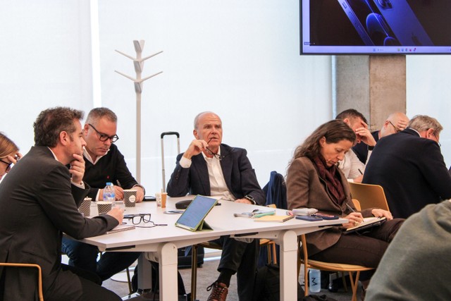 Un grupo de personas participando en una reunión alrededor de una mesa.