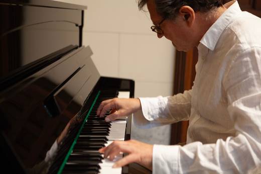 Un hombre está tocando el piano con concentración.