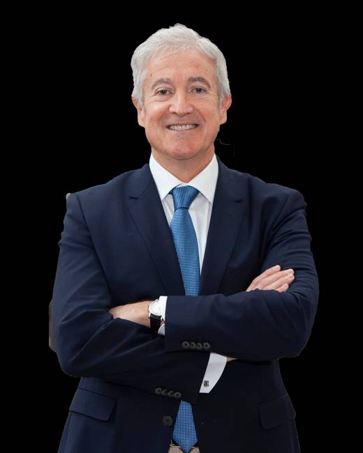 Hombre de negocios vestido con traje y corbata, sonriendo con los brazos cruzados.