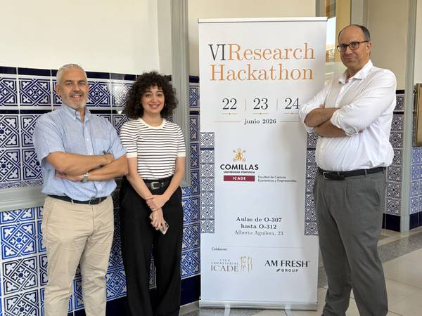 Tres personas posan frente a un cartel que anuncia un hackathon de investigación en Comillas.