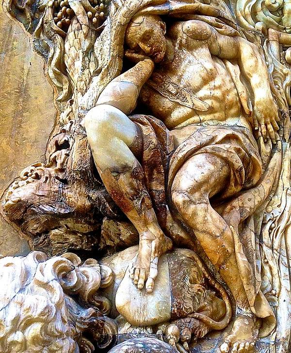 A detailed sculpture of two intertwined human figures carved with expressive motion and texture.