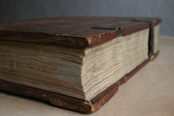 Un libro antiguo con cubierta de cuero y páginas amarillentas.