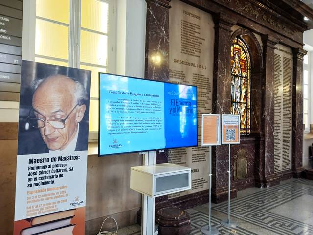 La imagen muestra una exposición en homenaje al profesor José González Cortázar, con una pantalla que presenta información sobre su legado.