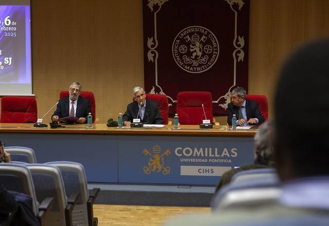 Un evento académico con tres ponentes sentados en una mesa en un auditorio de la Universidad Pontificia Comillas.