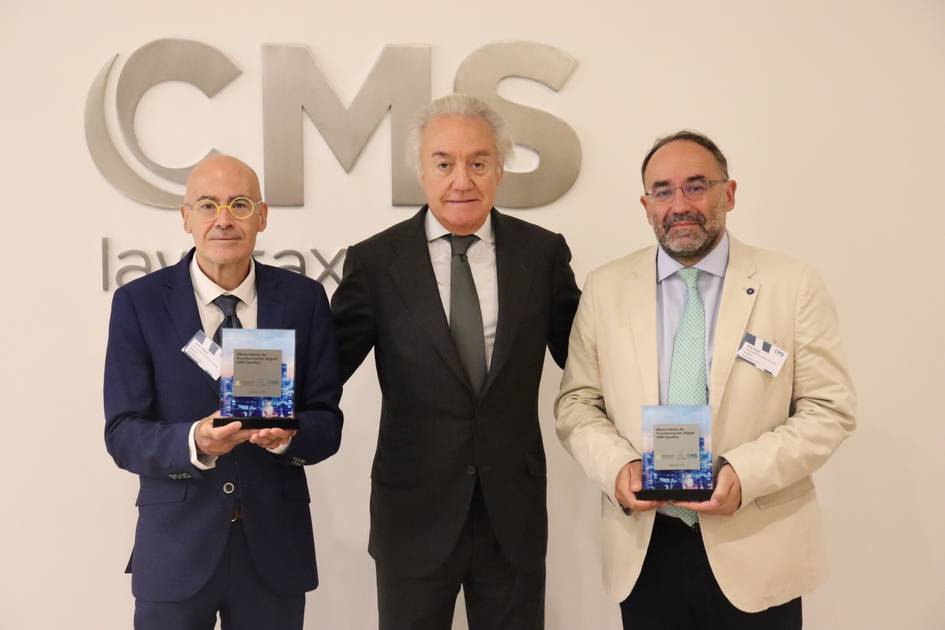 Three men standing in front of a 'CMS law tax' sign, each holding a small rectangular award.