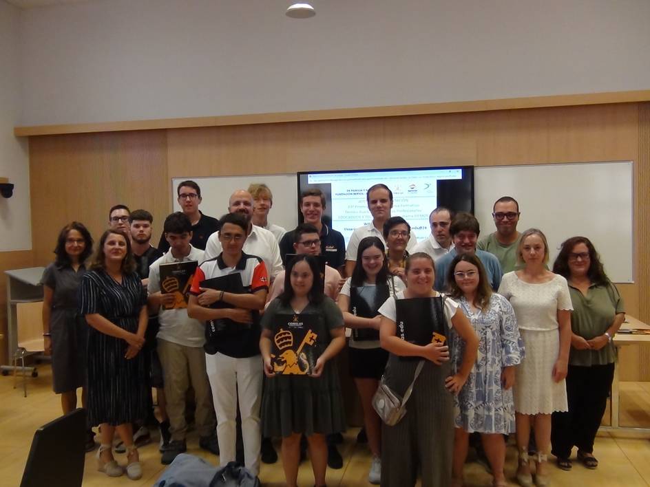 A group of people posing for a photo in a lecture room.